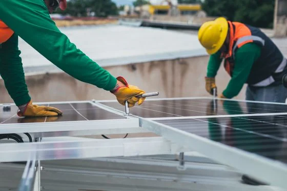 Técnico a instalar um painel solar no telhado de uma moradia